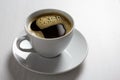 Freshly poured black coffee with froth in white ceramic cup isolated on white.