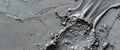 Freshly poured concrete flows smoothly over a textured gray surface, showcasing bubbles and unique patterns that highlight artisan