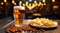 Freshly poured glass of light beer with foam and snacks, chips, nuts on a wooden table against a background of a blurred country Royalty Free Stock Photo