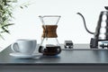 Freshly prepared black coffee in chemex pour over coffee maker near white coffee cup. 3d rendering Royalty Free Stock Photo