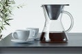 Freshly prepared black coffee in chemex pour over coffee maker near white coffee cup. Alternative brewing. 3d rendering