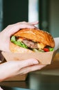Freshly prepared cheeseburger in a paper box. Takeaway or delivery concept Royalty Free Stock Photo
