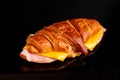 Freshly prepared croissant sandwich, made with ham and cheese, sitting on a black surface Royalty Free Stock Photo