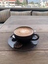 A freshly prepared cup of cortado coffee on an outdoor terrace