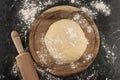 Freshly prepared dough on a wooden board.