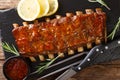 Freshly prepared grilled pork ribs with chili sauce and lemon close-up on a slate board. horizontal top view Royalty Free Stock Photo