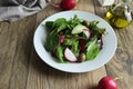 Freshly prepared salad made of greens, red radishes and green olives