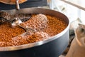 Freshly roasted coffee beans from a large roaster in the cooling cylinder. Motion blur on the beans, selective focus Royalty Free Stock Photo