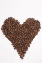 Freshly roasted coffee beans in shape of a heart isolated on white background. top view Royalty Free Stock Photo
