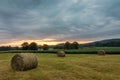 Freshly rolled bales of hay rest on a field at sunrise in Sussex County, NJ, late summer Royalty Free Stock Photo