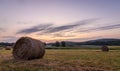 Freshly rolled bales of hay rest on a field at sunrise in Sussex County, NJ, late summer Royalty Free Stock Photo