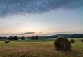 Freshly rolled bales of hay rest on a field at sunrise in Sussex County, NJ, late summer Royalty Free Stock Photo