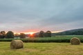 Freshly rolled bales of hay rest on a field at sunrise in Sussex County, NJ, late summer Royalty Free Stock Photo