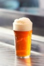 Fresh served pint of frothy draft beer in a glass