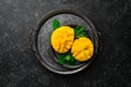 Freshly sliced mango on a metal plate. Tropical fruits. On a black stone background Royalty Free Stock Photo