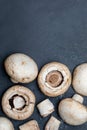 Freshly sliced mushrooms mushrooms, cut foot, Bisporus agaricus raw uncooked. Black slate background. Royalty Free Stock Photo