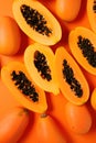 Freshly Sliced Papaya on Vibrant Orange Background AI Generated