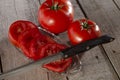 Sliced tomatoes with kitchen knife on wood planks