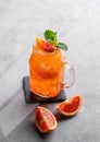 Freshly squeezed blood orange juice with ice, mint and a slice of fruit in a jar on a blue background Royalty Free Stock Photo