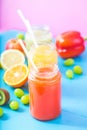 Freshly squeezed fruit juice, smoothies yellow orange green blue banana lemon apple orange kiwi grape strawberry on bright blue an Royalty Free Stock Photo