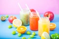 Freshly squeezed fruit juice, smoothies yellow orange green blue banana lemon apple orange kiwi grape strawberry on bright blue an Royalty Free Stock Photo