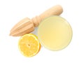 Freshly squeezed juice, half of lemon and reamer on white background, top view