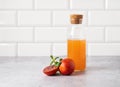 Freshly squeezed orange juice in a bottle on the kitchen table with fresh red oranges. The concept of a healthy drink. Front view