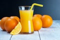 Freshly squeezed orange juice in glass with orange fruits on wooden background Royalty Free Stock Photo