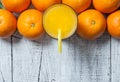 Freshly squeezed orange juice in glass with orange fruits on wooden background Royalty Free Stock Photo