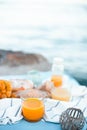 Freshly squeezed orange juice in a glass glass, ripe grapes and cheese on a blanket. Picnic by the sea. Healthy food and nutrition Royalty Free Stock Photo