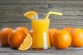 Freshly squeezed orange juice in glass with orange fruits on wooden background Royalty Free Stock Photo