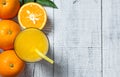 Freshly squeezed orange juice in glass with orange fruits on wooden background Royalty Free Stock Photo