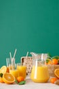 Freshly squeezed orange juice in a glass pitcher and fresh fruits with leaves, healthy drink, vitamin c concept, front view, copy Royalty Free Stock Photo