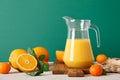 Freshly squeezed orange juice in a glass pitcher and fresh fruits with leaves, healthy drink, vitamin c concept, front view, copy Royalty Free Stock Photo