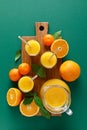 Freshly squeezed orange juice in a glass pitcher and fresh fruits with leaves, healthy drink, vitamin c concept, overhead view Royalty Free Stock Photo