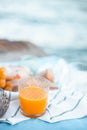 Freshly squeezed orange juice in a glass glass, ripe grapes and cheese on a blanket. Picnic by the sea. Healthy food and nutrition Royalty Free Stock Photo