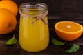 Freshly squeezed orange juice in a jar on a dark wooden background. Royalty Free Stock Photo