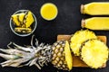 Freshly squeezed pineapple juice near fruit slices on black background top view Royalty Free Stock Photo