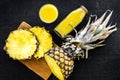 Freshly squeezed pineapple juice near fruit slices on black background top view Royalty Free Stock Photo