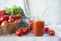 Freshly squeezed tomato juice in a glass cup and ripe tomatoes in a basket Royalty Free Stock Photo