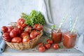 Freshly squeezed tomato juice in a glass cup and ripe tomatoes in a basket Royalty Free Stock Photo