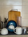 Freshly washed dishes drying on a kitchen counter with cups, bowls, utensils, and cutting boards. Royalty Free Stock Photo