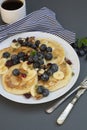 Freshmade, homemade pancakes with blueberry, dried fruits and honey. Breakfast with coffee and pancakes. Deliciious