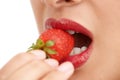 Freshness comes in red. Cropped closeup shot of a young woman biting into a strawberry. Royalty Free Stock Photo