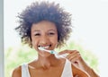 For the freshness to last, you must brush twice a day. an attractive young woman brushing her teeth in the bathroom at Royalty Free Stock Photo