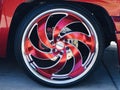 Close up photo of a cool red shiny custom truck rim