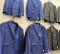 New 2021 Mens blue and black suits hanging in store