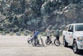 A family sitting on their bikes outside near Morro Bay Rock wearing face masks in 2021
