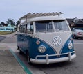 A front view of a vintage parked blue and white VW Bus with rack at Morro Bay, Ca.