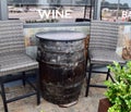 Photo of two chairs and a wine barrel table outside of restaurant on a sunny day